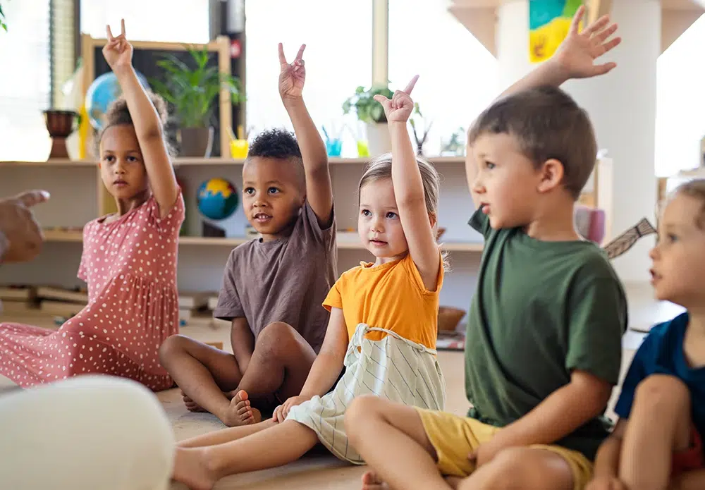 idee-on-kinder-in-der-betreuung-sitzkreis Kinder sitzen im Sitzkreis und melden sich